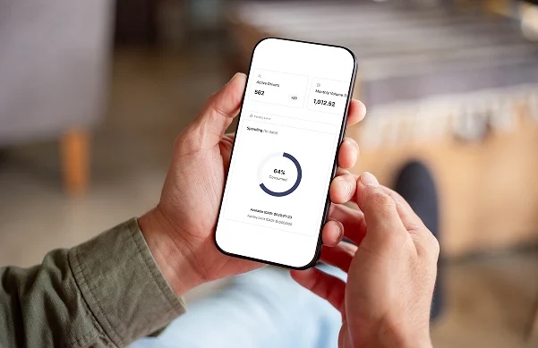 The Nomad Fuel app dashboard open on a phone held in both hands