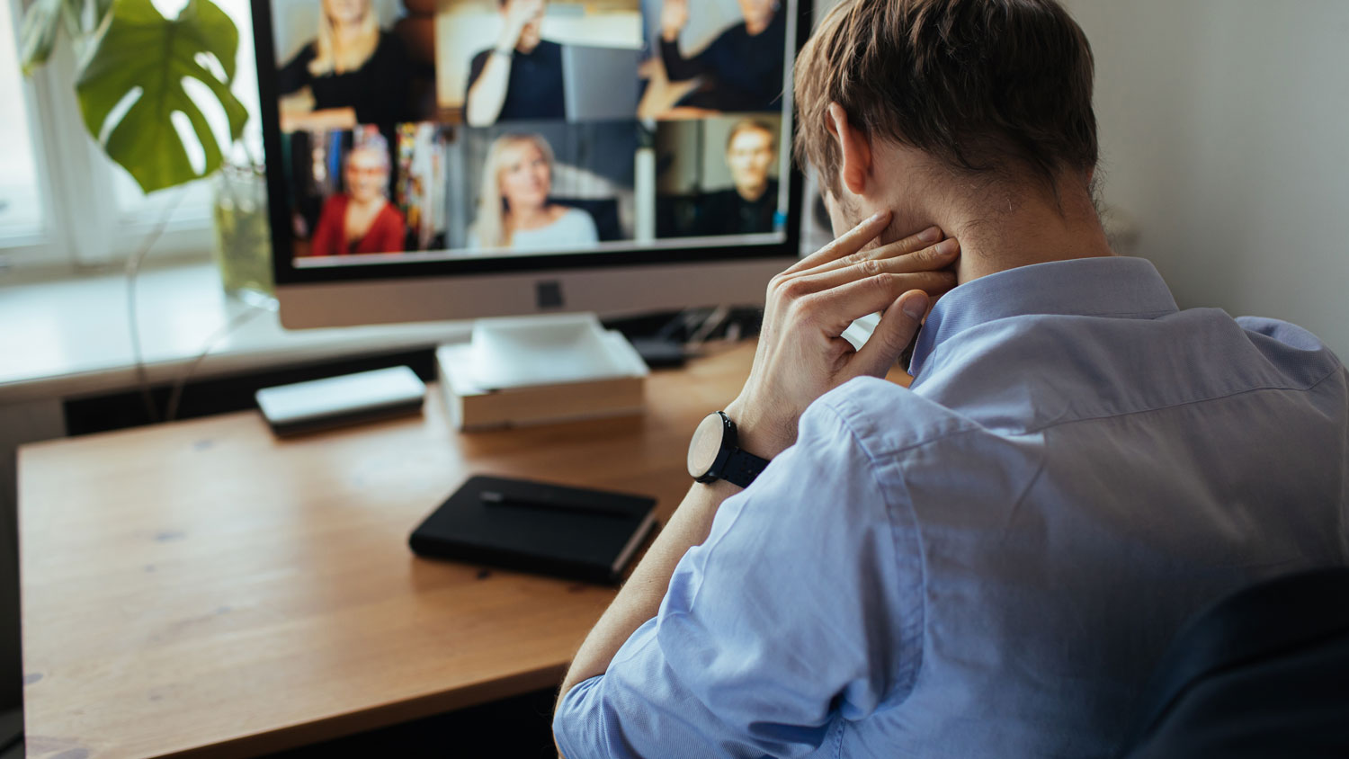 Remote worker in a zoom meeting experiencing symptoms of a remote-work lifestyle.