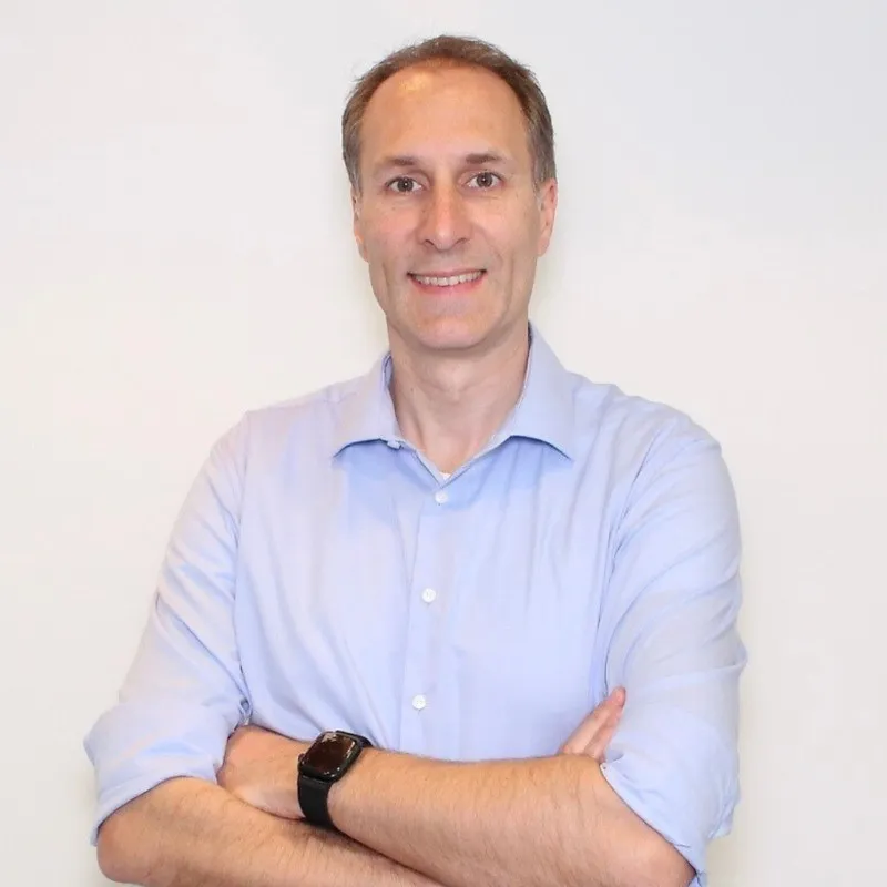 Michael Mauerhoff von sparepartsnow mit hellblauem Hemd, vor hellem Hintergrund, mit verschränkten Armen