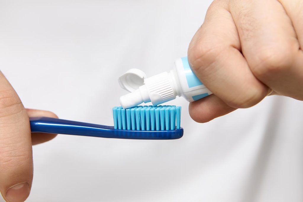 close-up-image-man-s-hands-holding-tube-squeezing-whitening-toothpaste-brush-dental-dost-dental-blog