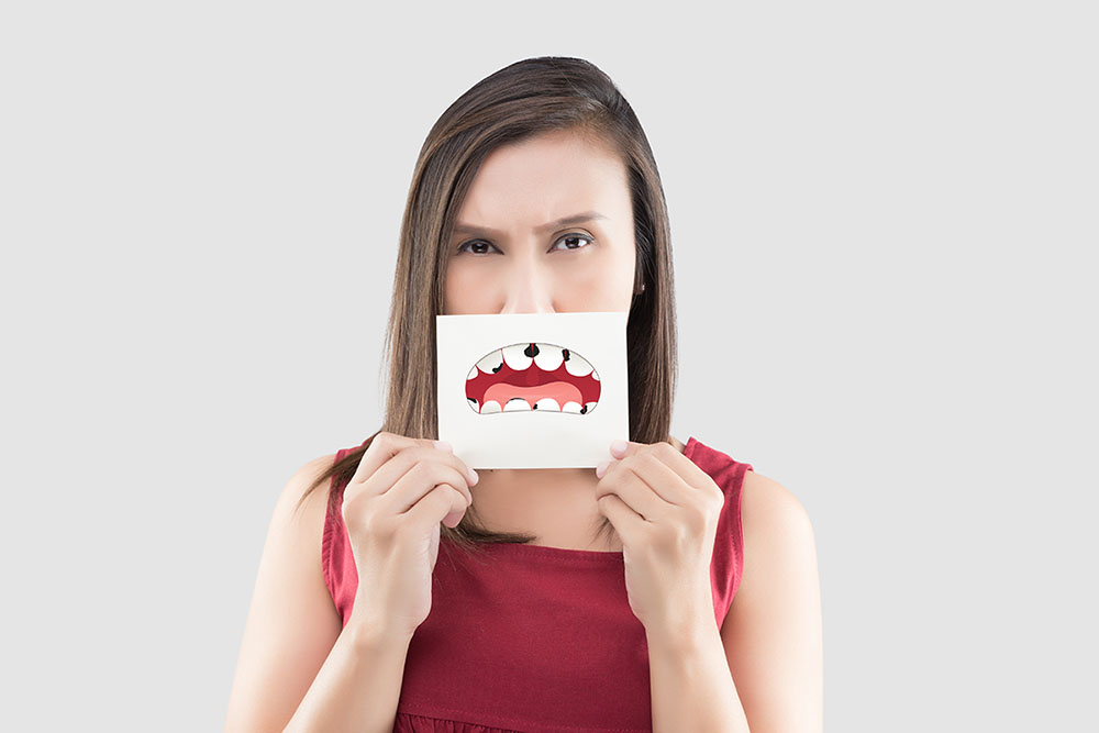 woman-holding-paper-with-broken-tooth-cartoon-gingivitis