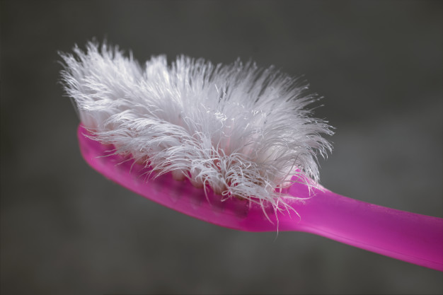 close-up-used-pink-toothbrush-with-cement-background-dental-blog
