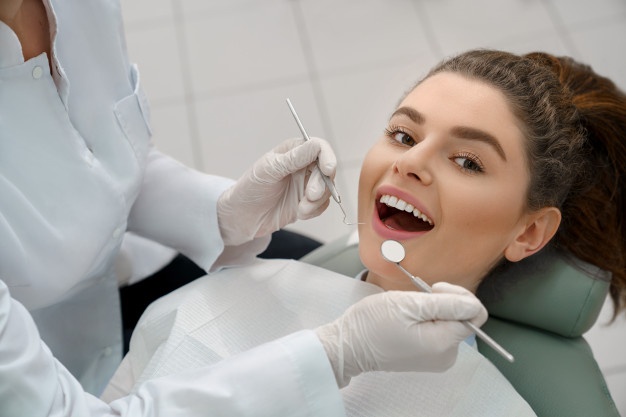 happy-woman-lying-dentist-chair-5 new year resolutions to improve your oral health