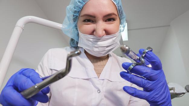 portrait-dentist-woman-doctor-uniform-is-holding-dental-instruments-forceps-needle-hands-patient-point-view