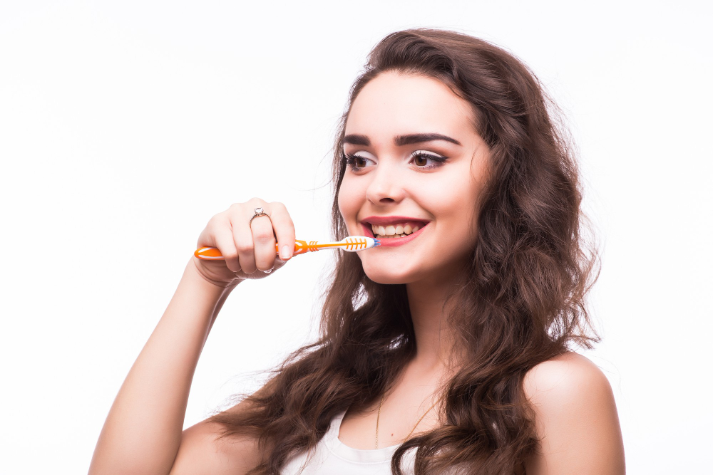 young-woman-with-great-teeth-holding-tooth-brush-brushing-her-teeh