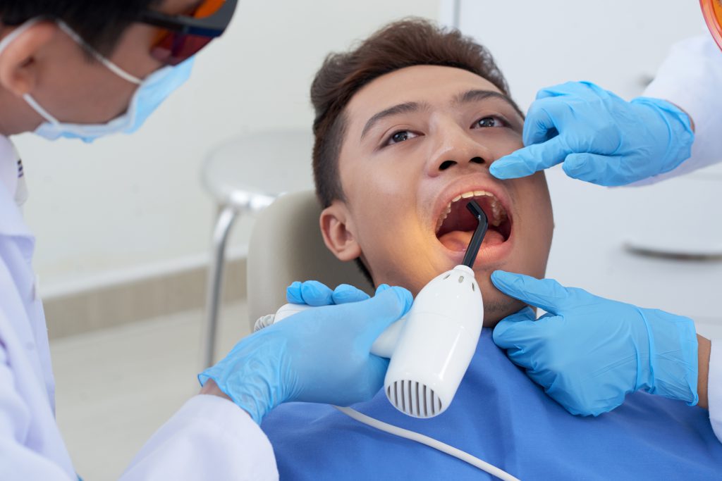 Dentist preparing tooth for dental filling