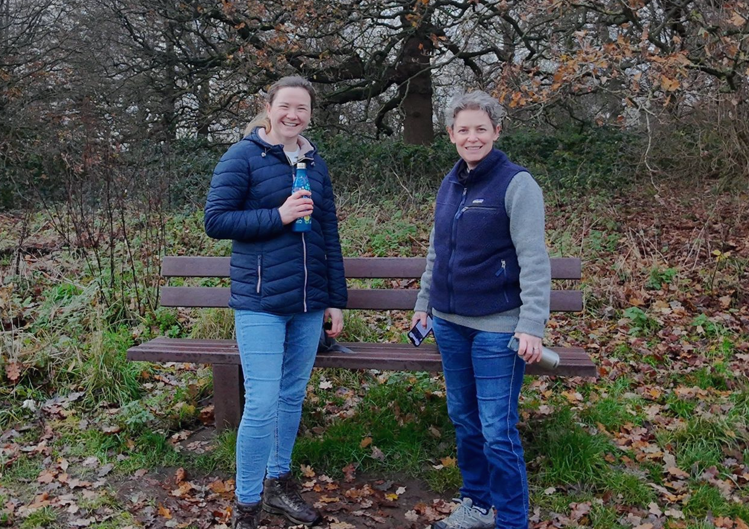 Katy Light and Helen Young standing in a field with autumn colours in the background.