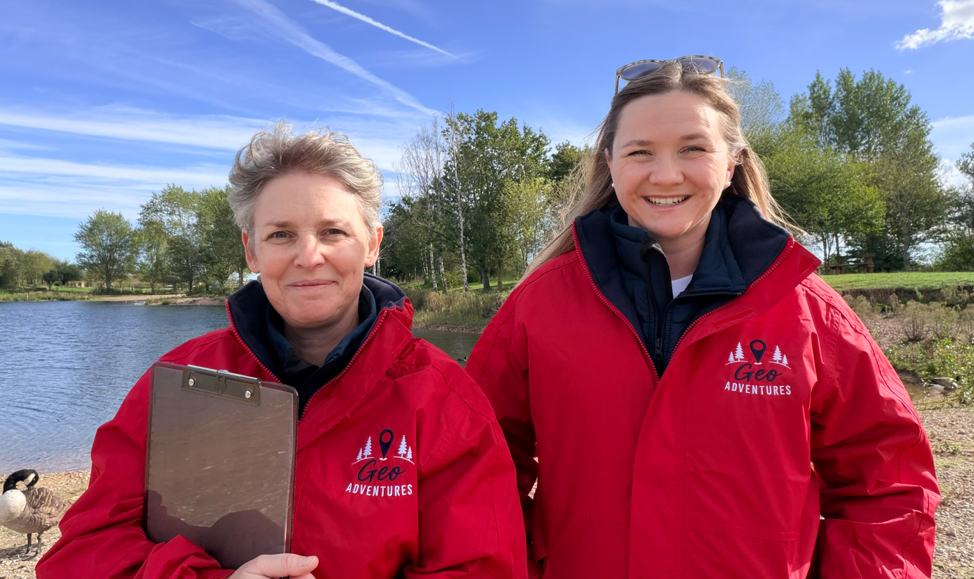 Katy Light and Helen Young standing in a field with autumn colours in the background.