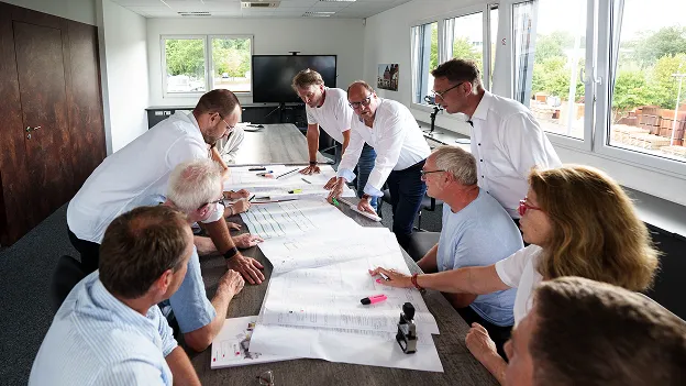 Projektteam von Sigler Schumer Spieth diskutiert Bauzeichnungen bei einer Planungsrunde