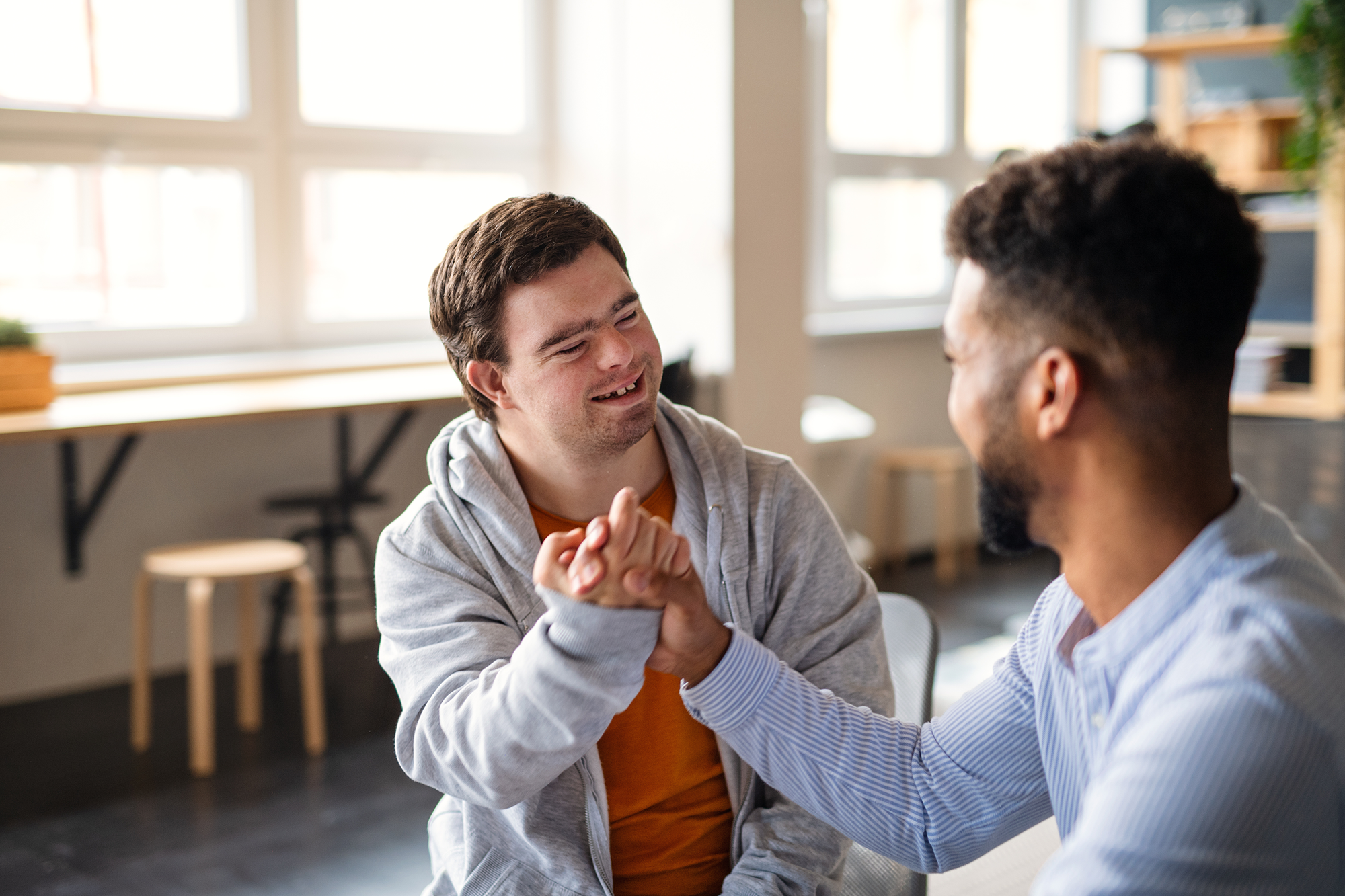 To personer gjør en handshake lyst rom – uttrykker vennskap og tillit.