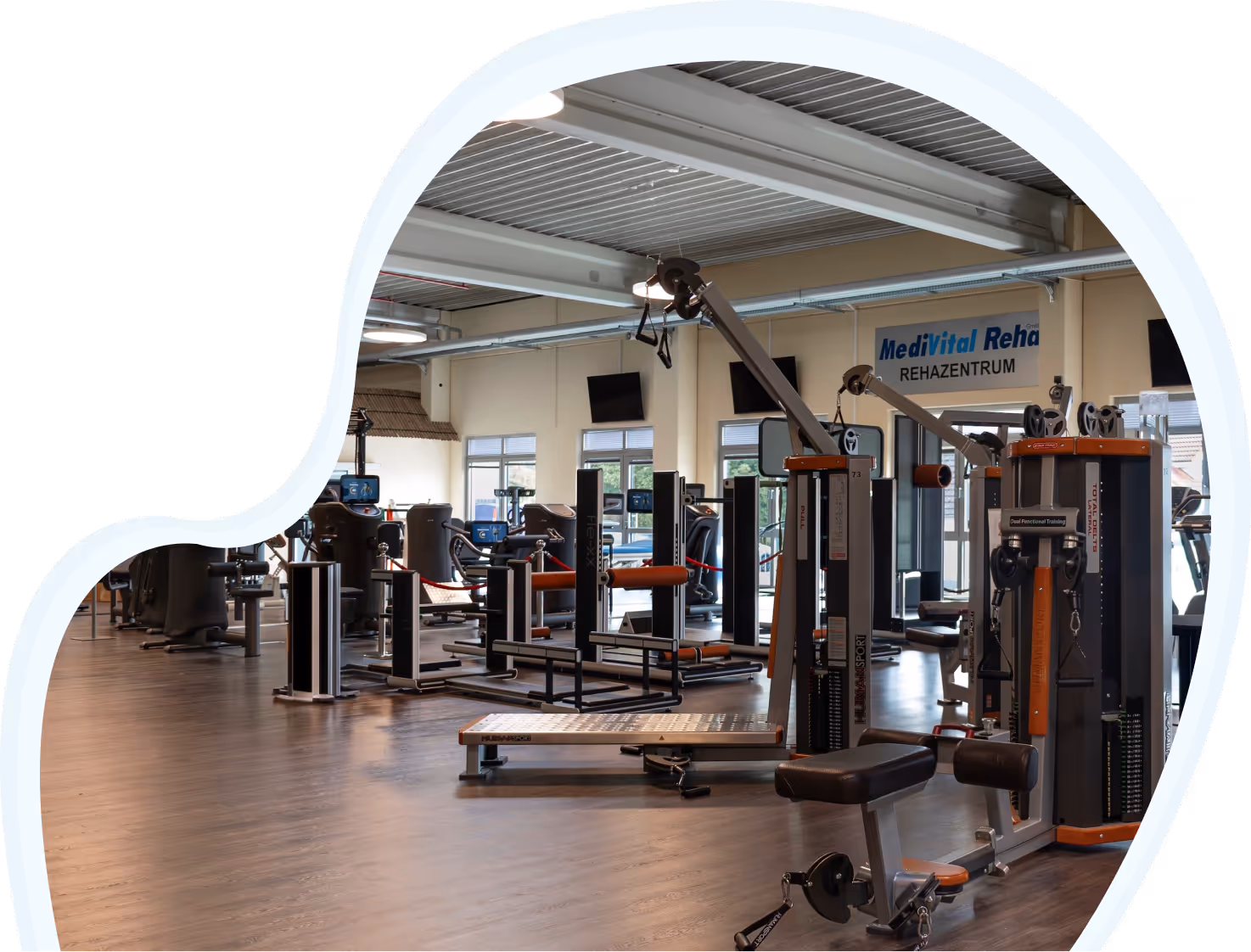 Großzügiges Fitness- und Rehabilitationszentrum mit verschiedenen Trainingsgeräten und -ausrüstungen unter Deckenbeleuchtung.