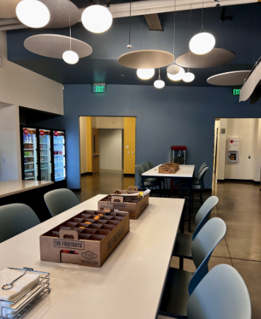 Modern workplace kitchen with tiered fruit baskets and napkin setup
