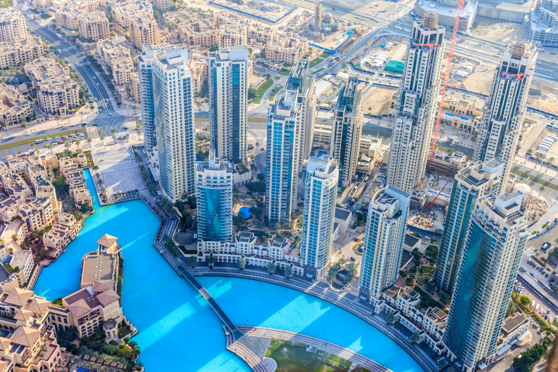 Vue aérienne de gratte-ciel modernes avec un grand bassin bleu turquoise en forme de lagon en avant.
