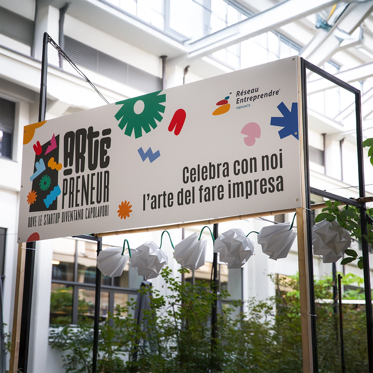 Insegna dell’evento Artepreneur di Réseau Entreprendre Piemonte: banner con logo e payoff “Celebra con noi l’arte del fare impresa” installato all’ingresso della location, parte del sistema di branding e wayfinding curato da Digistart.