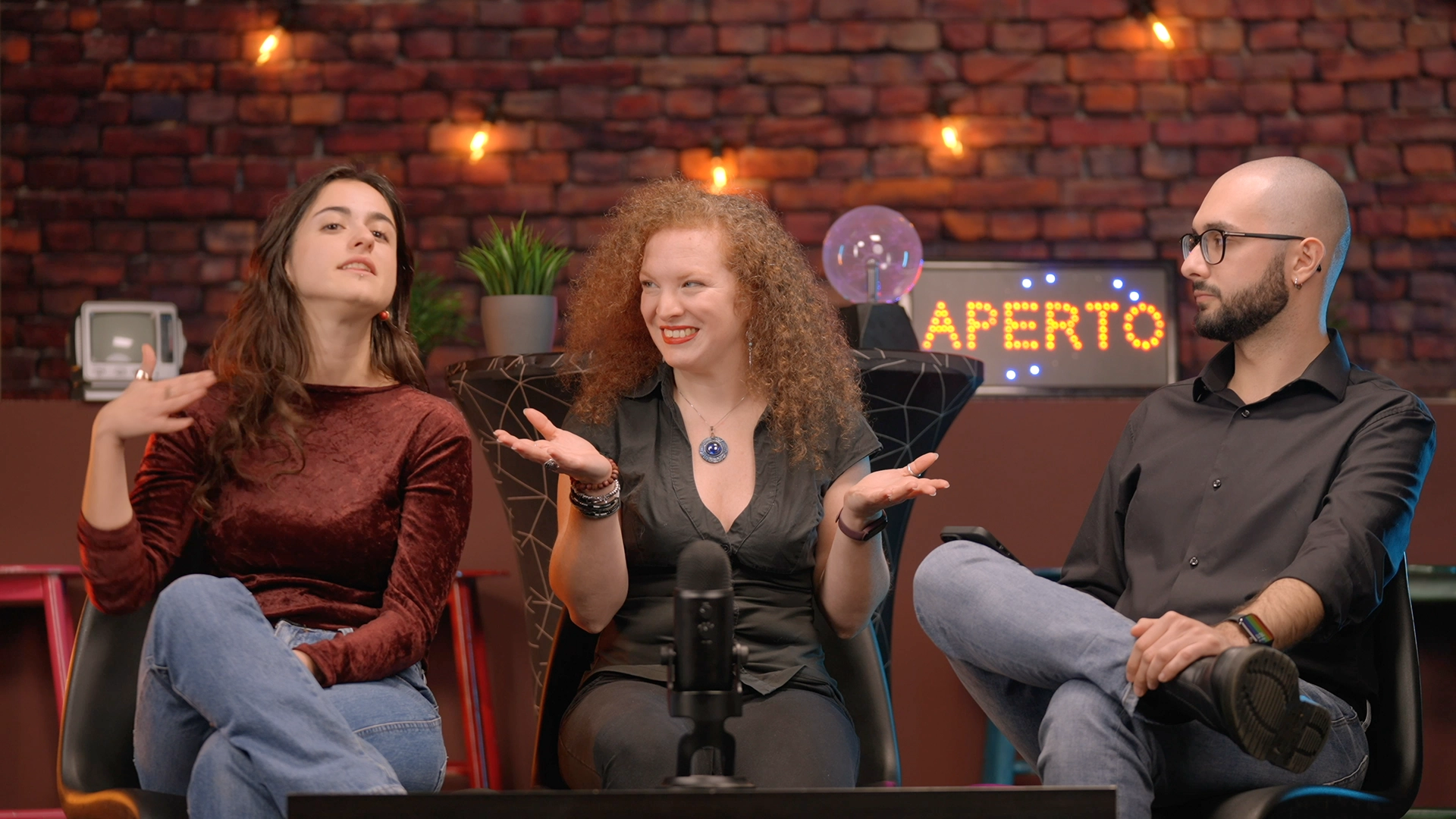 Set del podcast AIAIAI per Università di Torino: tre ragazzi seduti attorno a un tavolo con microfono e oggetti scenografici, mentre discutono di intelligenza artificiale in uno studio allestito da Digistart, agenzia creativa a Torino.