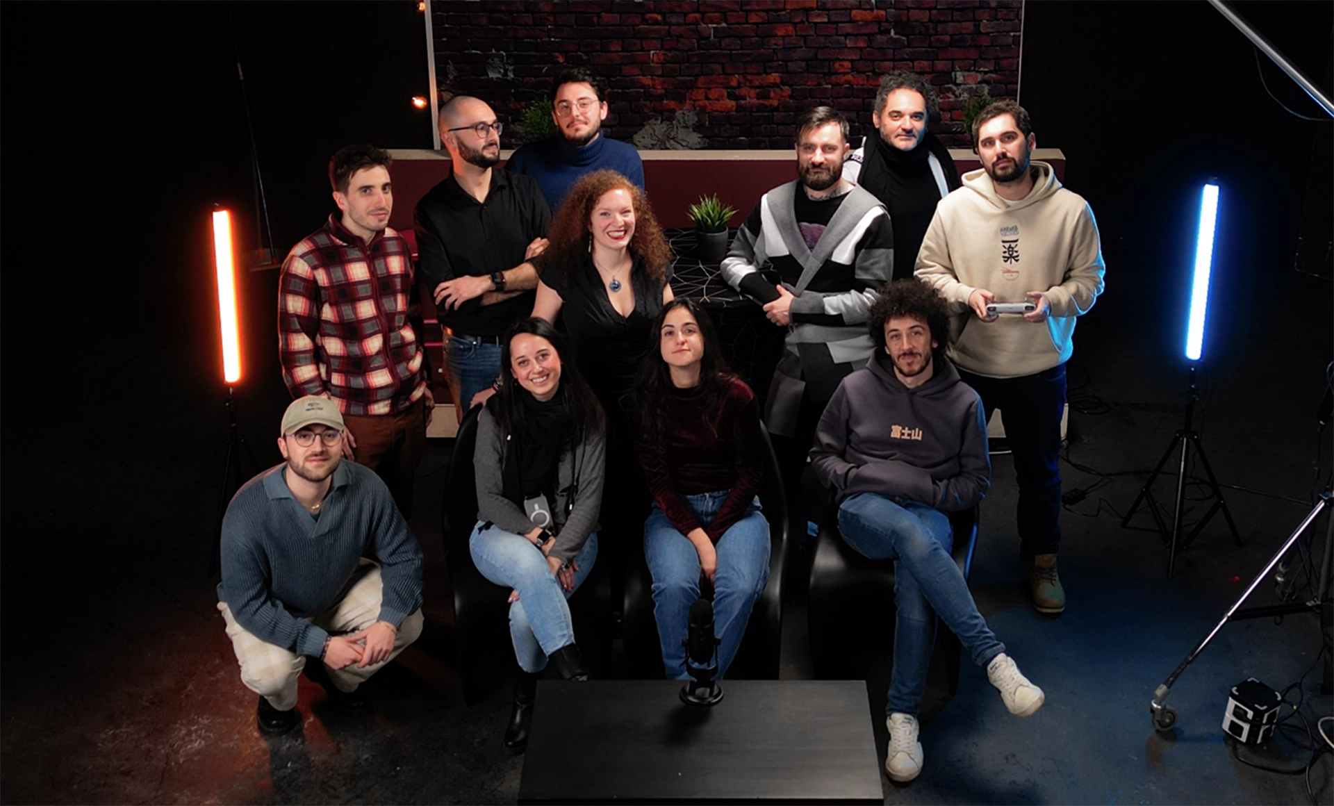 Set del podcast AIAIAI per Università di Torino: foto di gruppo con conduttori e ospiti seduti in studio, luci colorate e microfoni, produzione video e podcast a cura di Digistart, agenzia creativa a Torino.