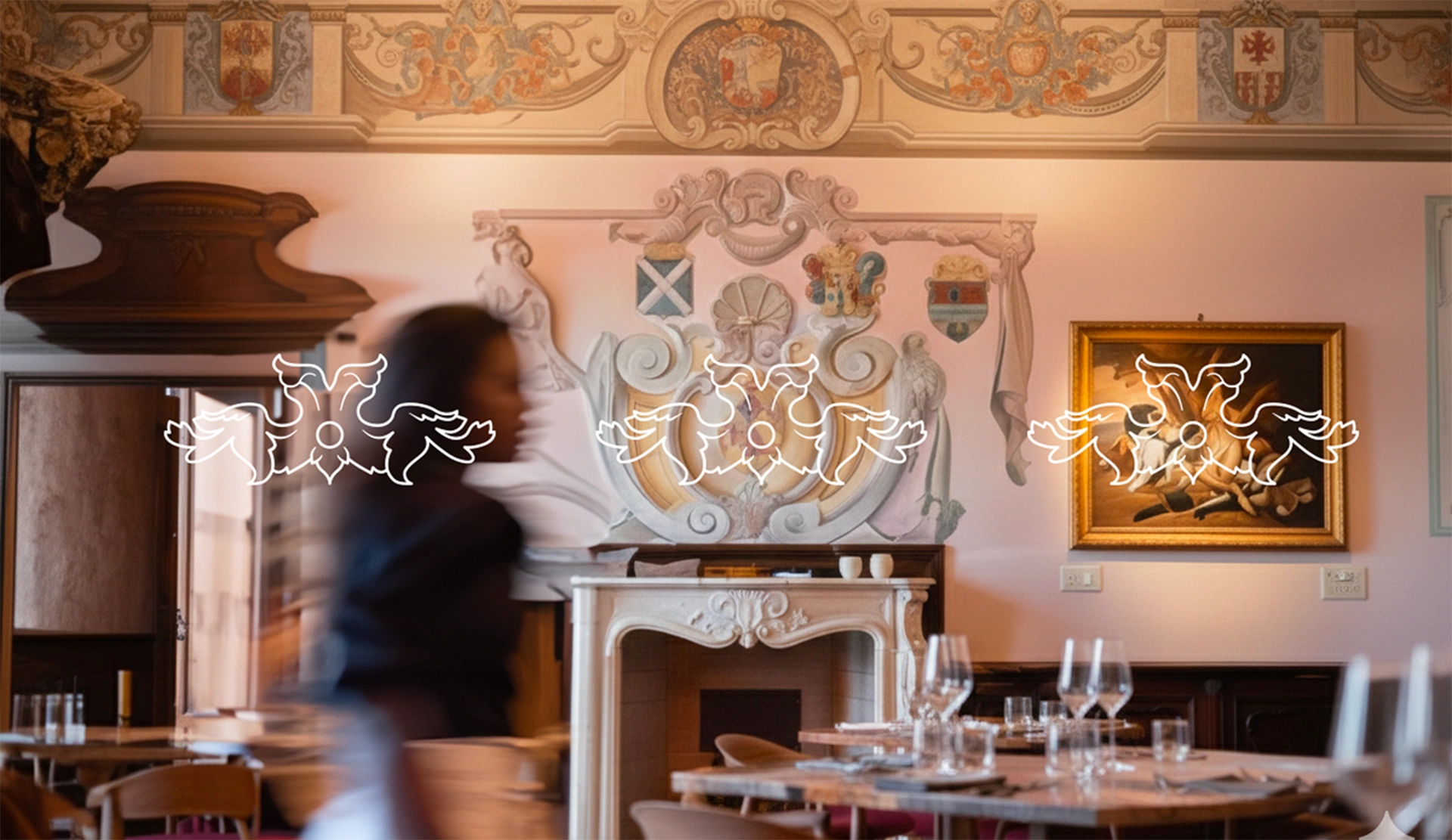 Interno del ristorante Nevia a Villarbasse: sala con camino decorato, affreschi e tavoli apparecchiati, con una cameriera in movimento a dare dinamismo alla scena, foto Digistart.