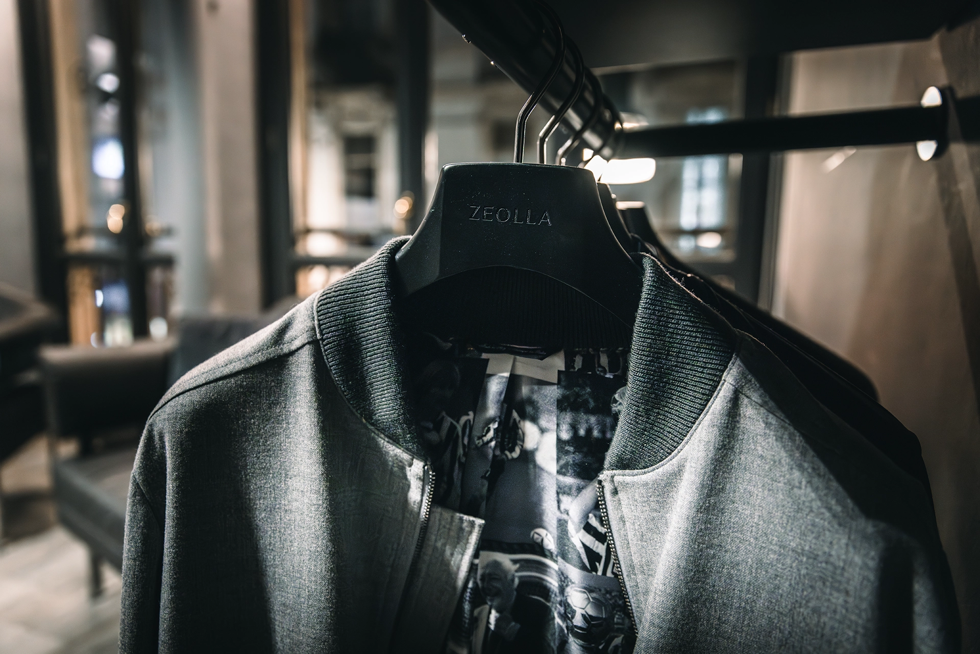 Dettaglio giacca sartoriale appesa su gruccia personalizzata Zeolla all’interno dell’atelier di moda maschile a Torino, fotografia che racconta cura dei capi e identità del brand, scatto Digistart.