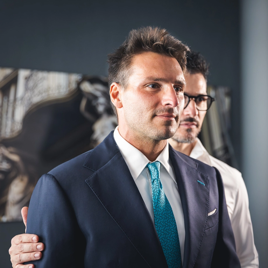 Momento di prova abito nell’atelier Zeolla, moda maschile a Torino: cliente in giacca e cravatta durante la consulenza sartoriale, accompagnato dal sarto, immagine che racconta l’esperienza su misura, foto Digistart.