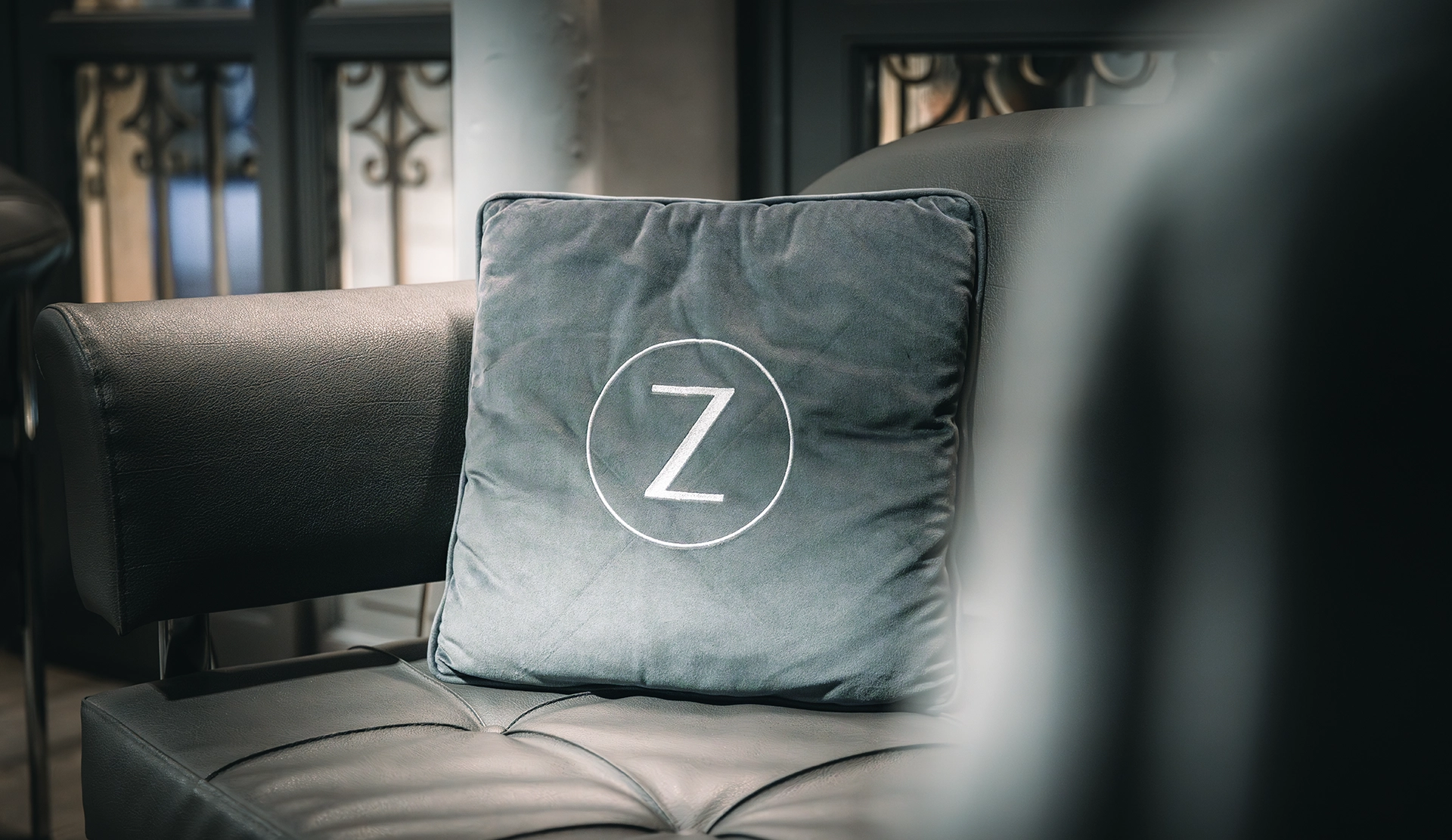 Dettaglio degli interni dell’atelier Zeolla: cuscino con logo Z su divano elegante, fotografia che mette in risalto branding, atmosfera e accoglienza del negozio, scatto Digistart.