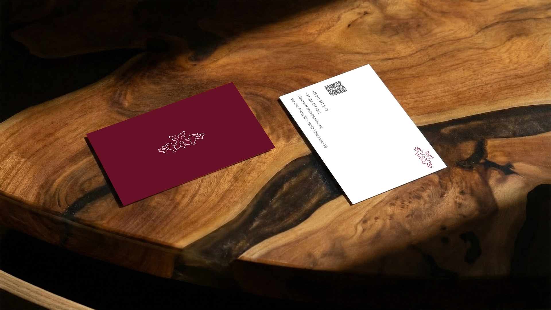 Dettaglio di brand identity per Nevia – Cucina e Miscelazione: card con logo del ristorante appoggiata su piatto nero con posate, fotografia che racconta eleganza e cura dei dettagli, scatto Digistart.