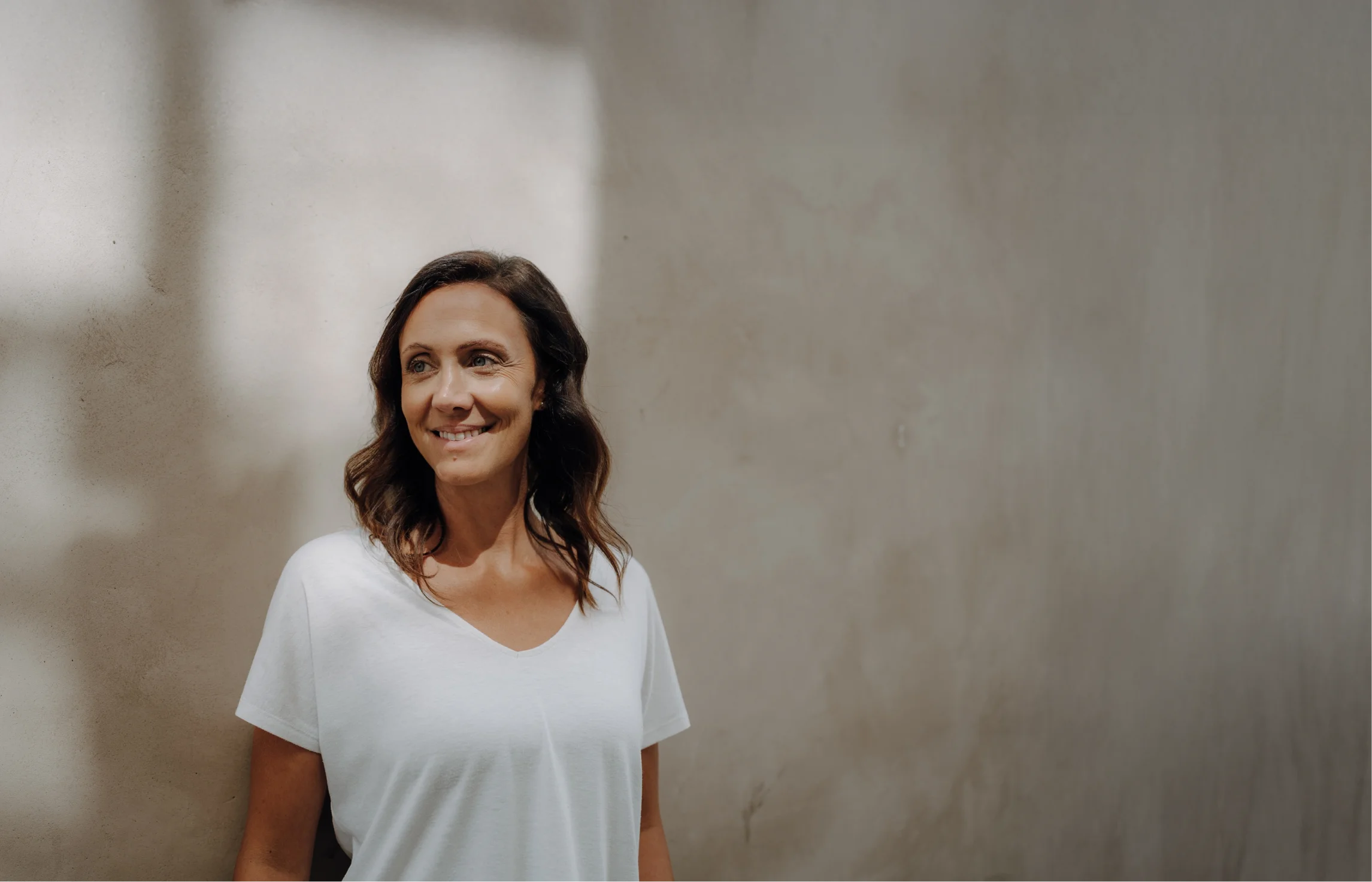 Diätologin Johanna Feichtl steht lächelnd vor einer hellen Wand..