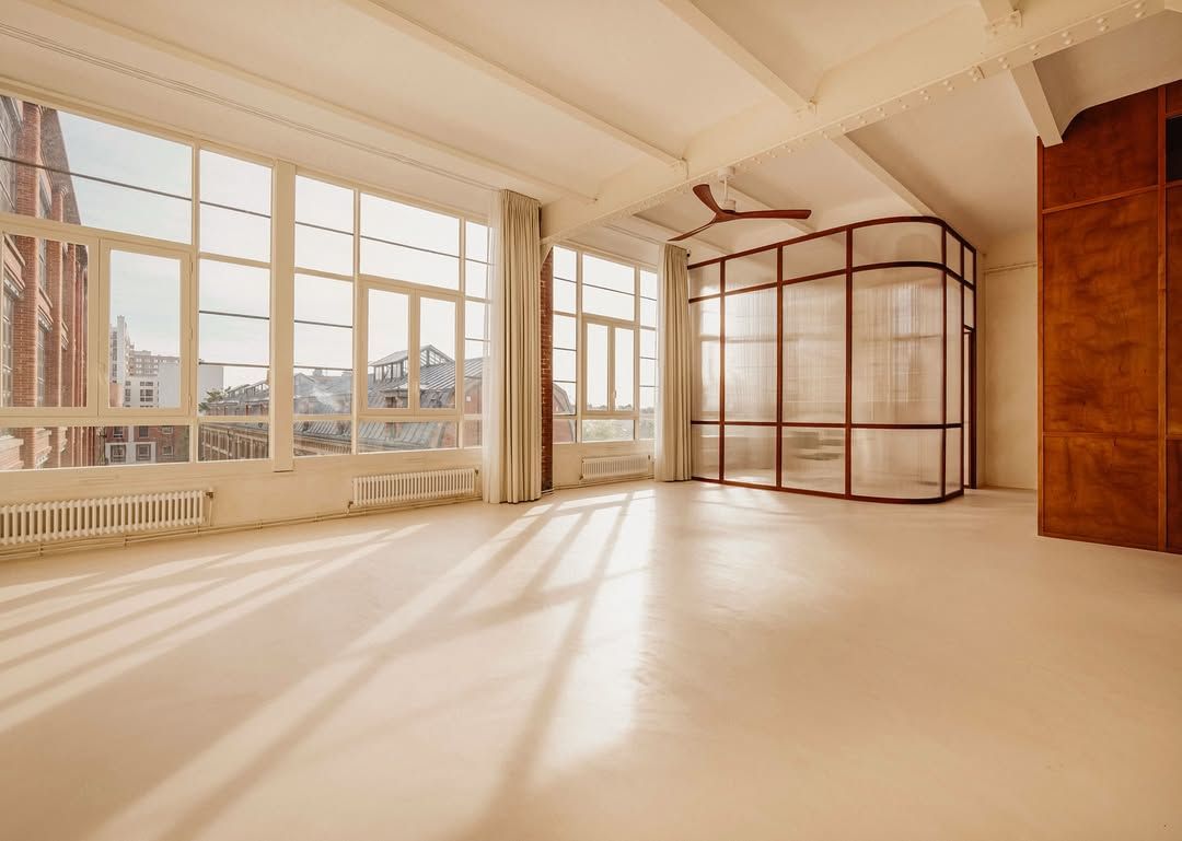 Artisan appliquant un béton ciré beige sur le sol d’un studio à Ivry-sur-Seine