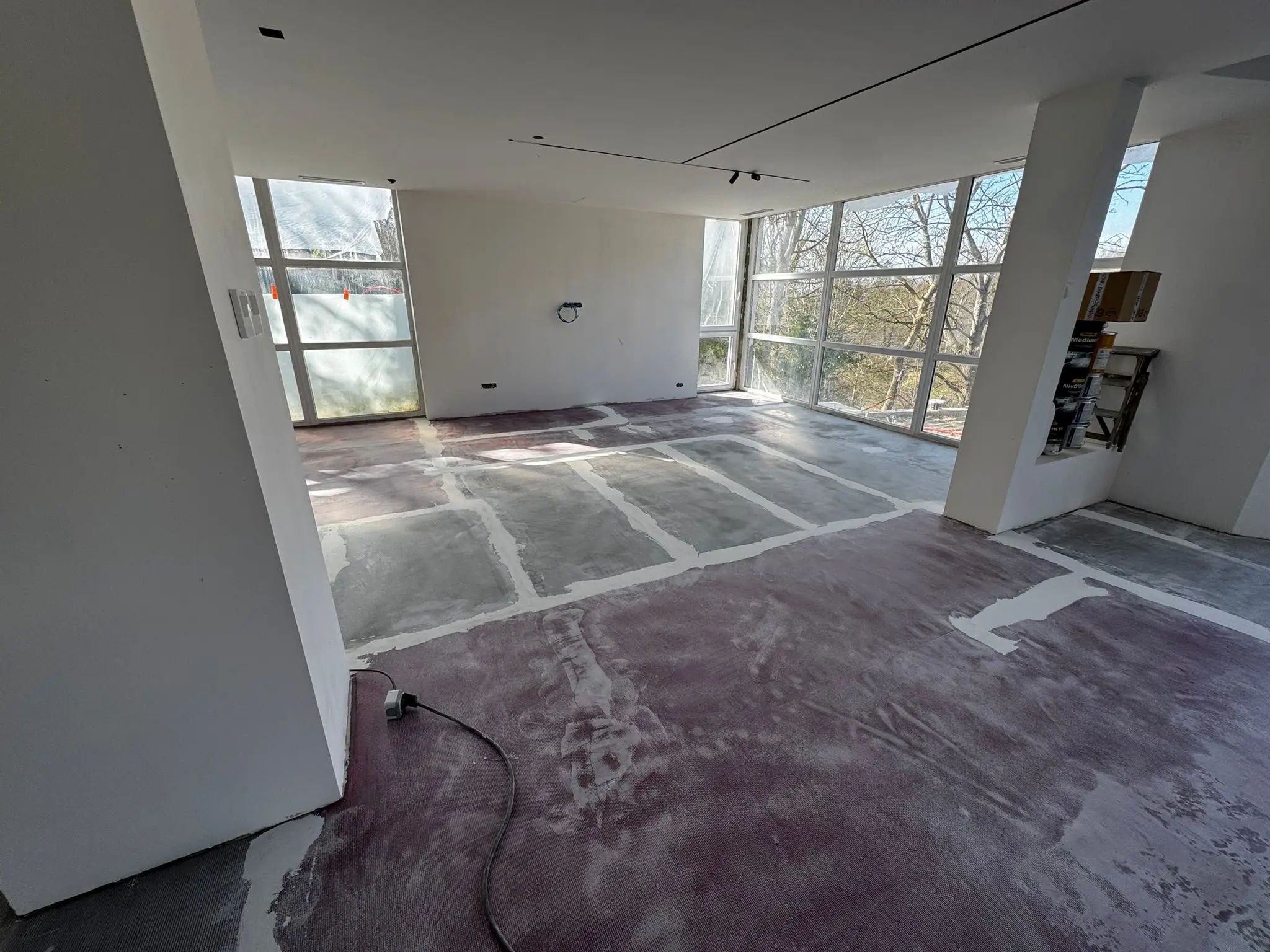 Rez-de-chaussée en chantier avant la mise en œuvre du béton ciré gris par un professionnel Brokkr