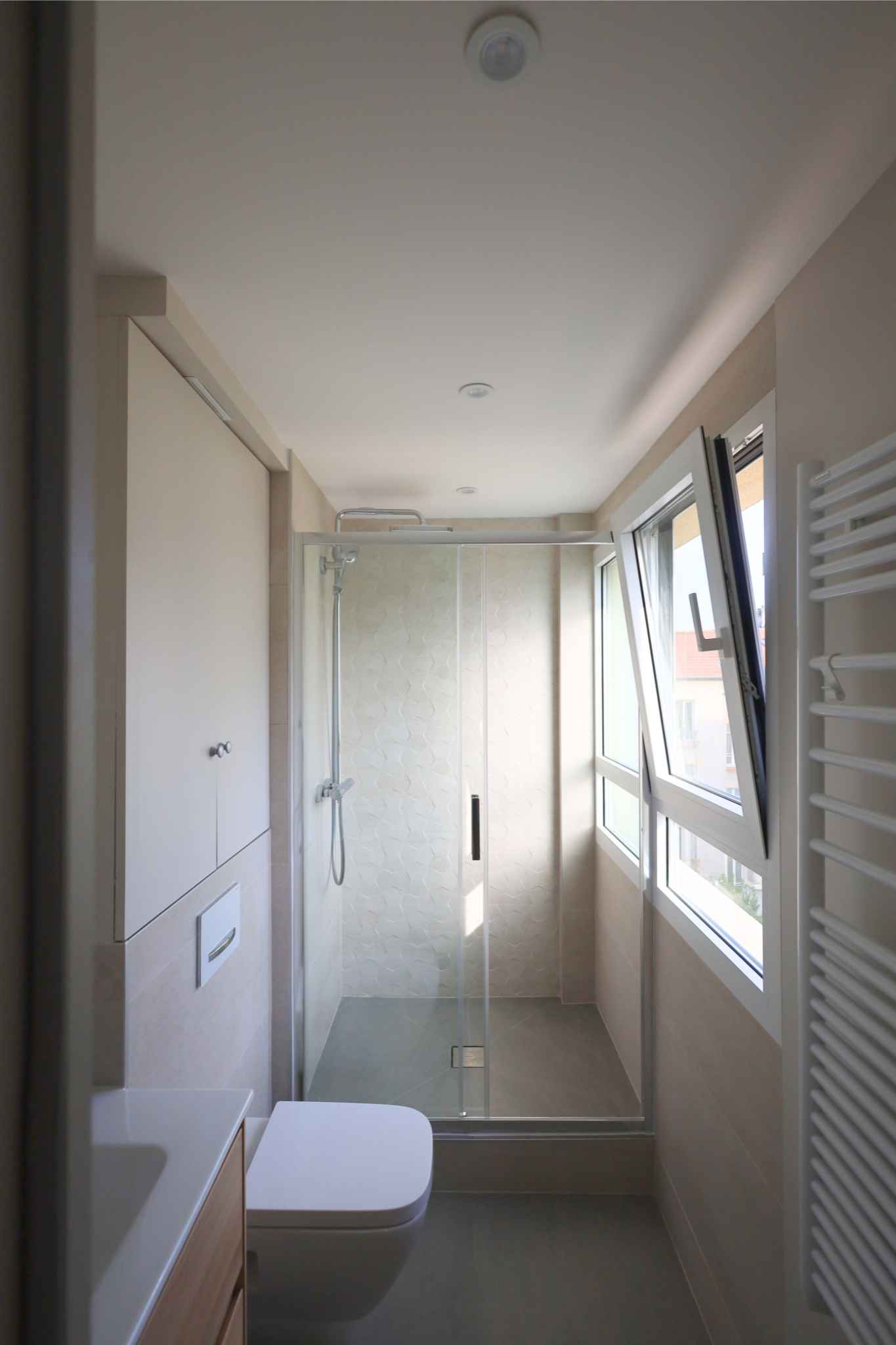 Salle d’eau de 9 m² modernisée avec éclairage LED et rangement fonctionnel.