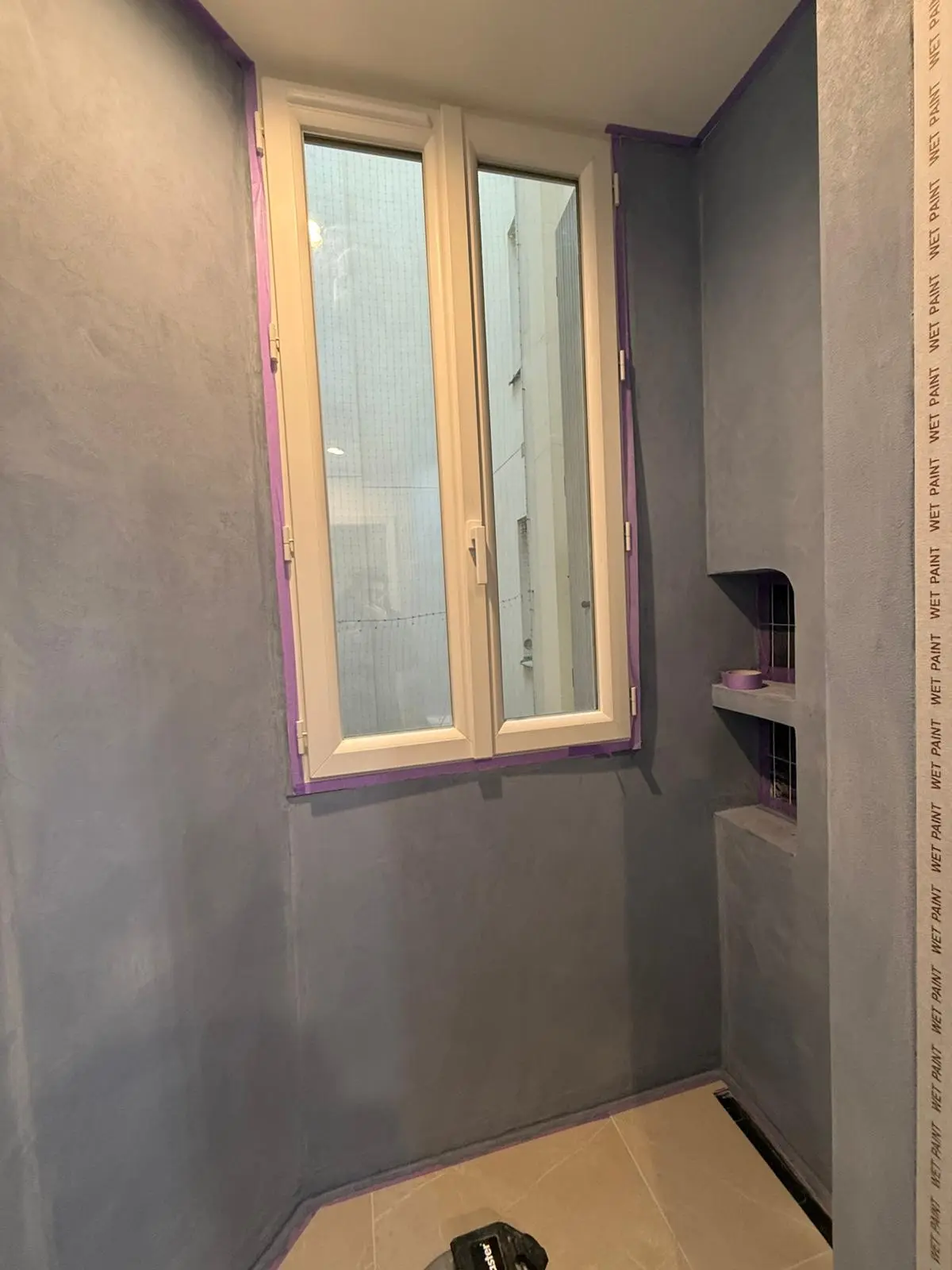 Pose de beton cire dans une douche dans une salle de bain à Paris.