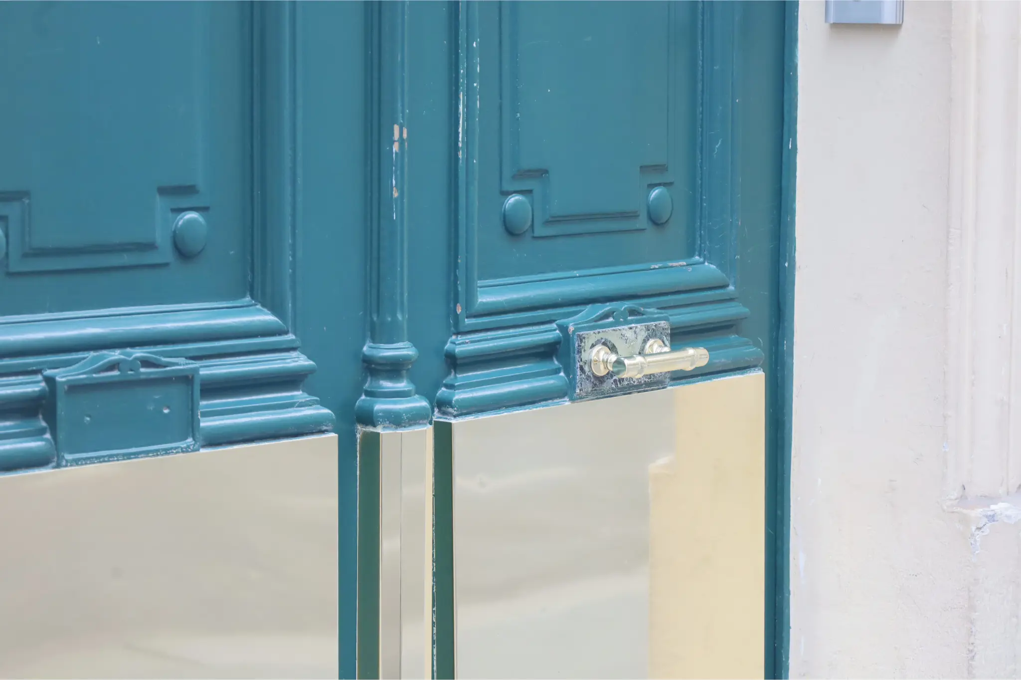 Pose de laiton sur une porte en cours de rénovation à Paris.