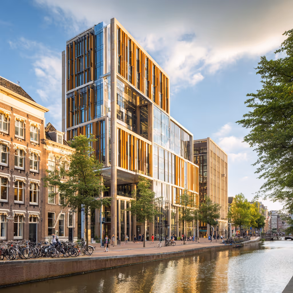 Moderne kantoorgebouwen langs een gracht met fietsen geparkeerd aan de waterkant bij zonnig weer.
