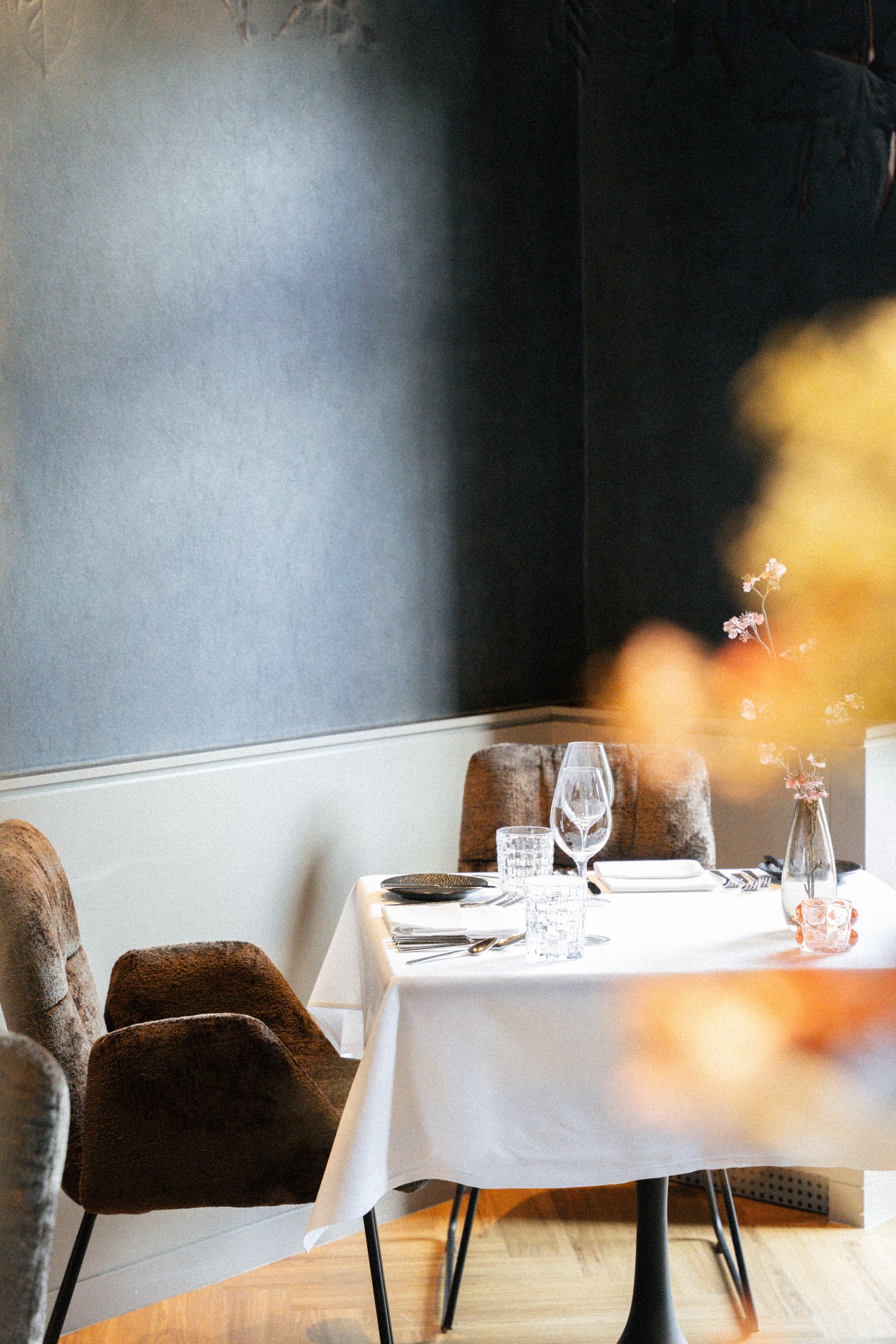 Tisch im Restaurant mit Deko und blauer Tapete im Hintergrund