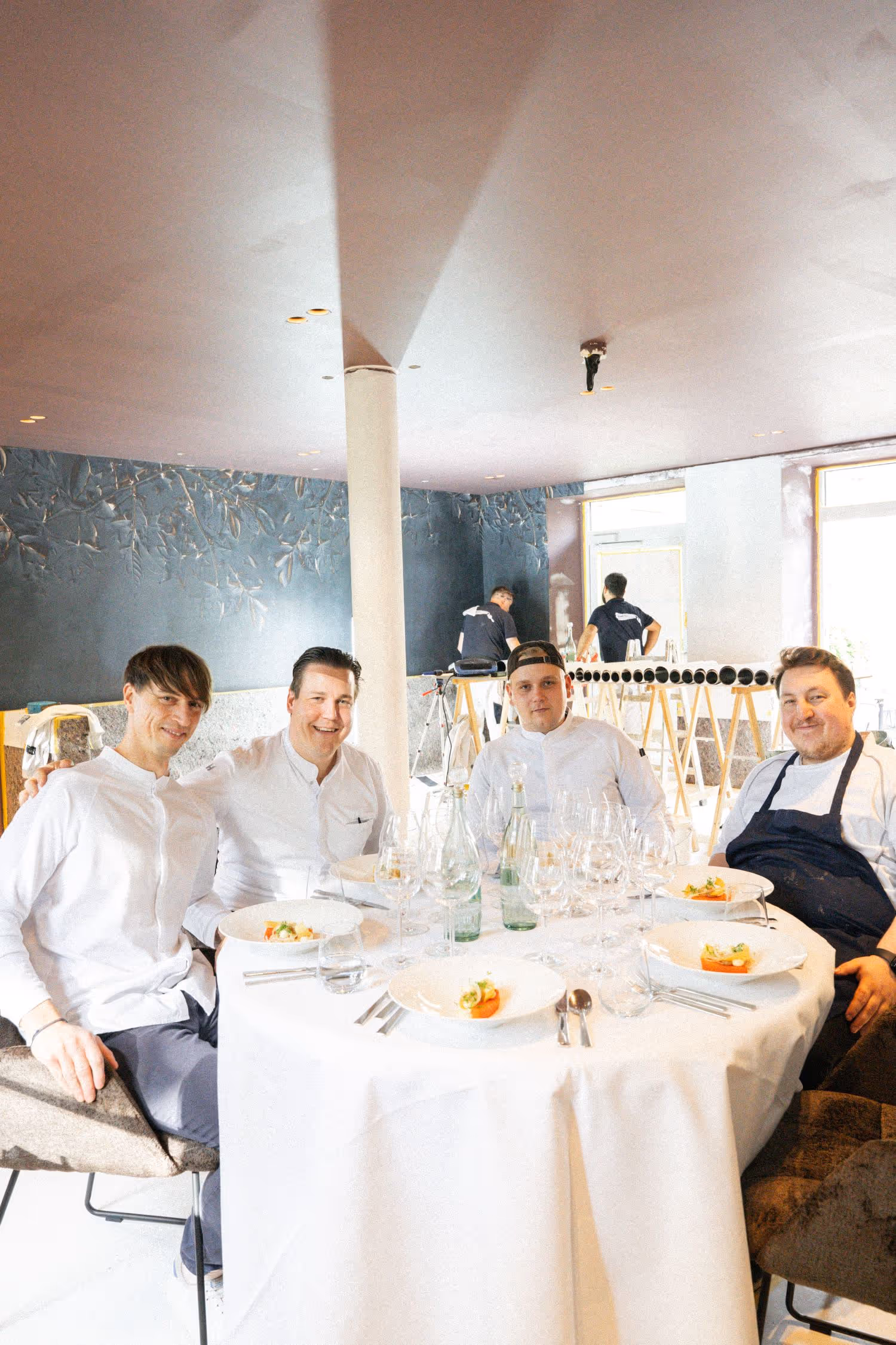 Teamfoto von vier Köchen am Tisch im Restaurant