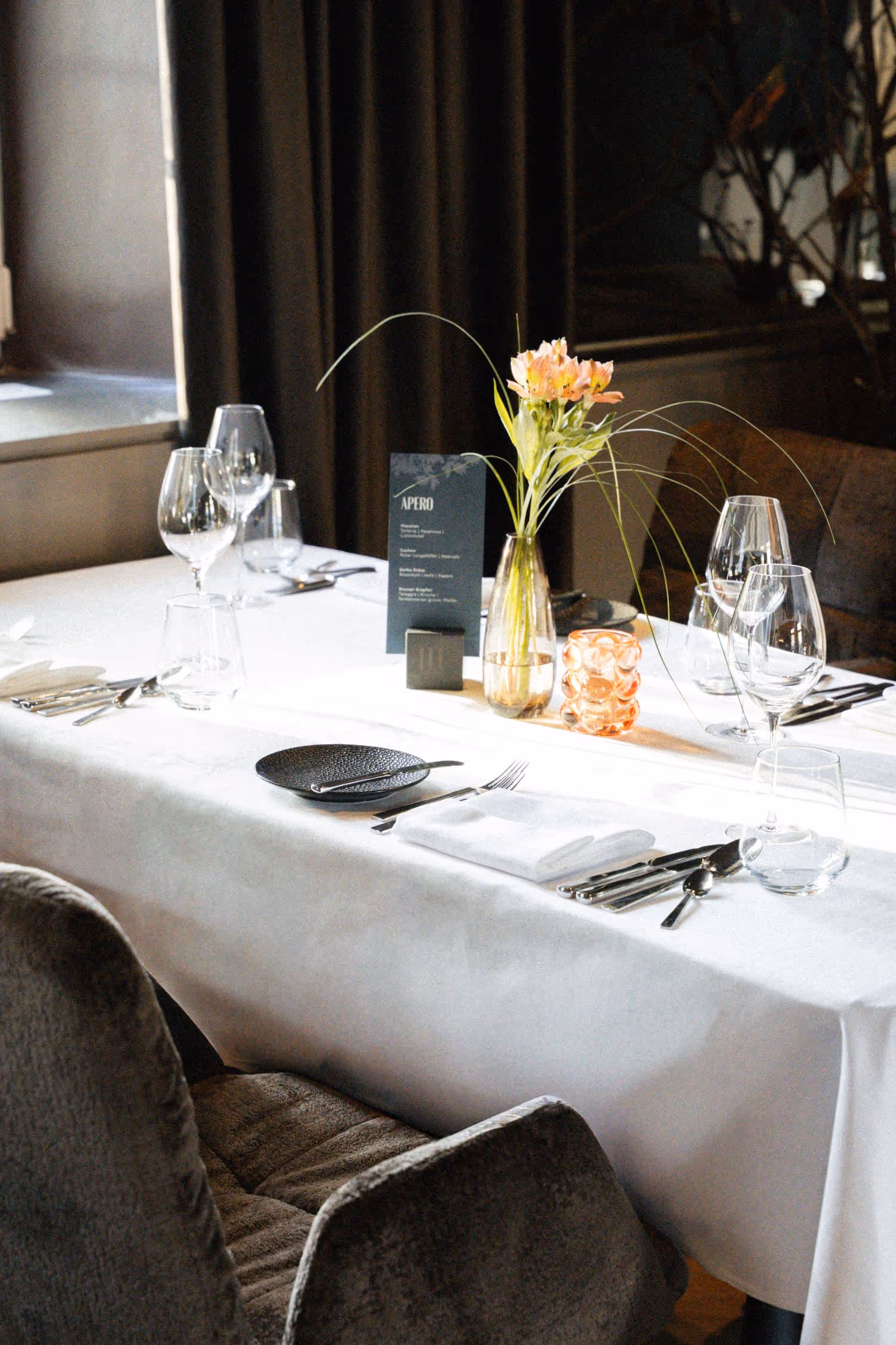 Eingedeckter Tisch im Restaurant mit Deko und Vorhang im Hintergrund