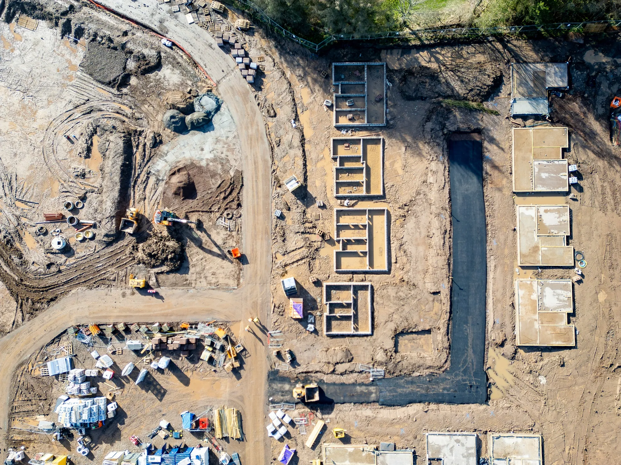 View of a construction site from a drones view, showing materials and building progress.