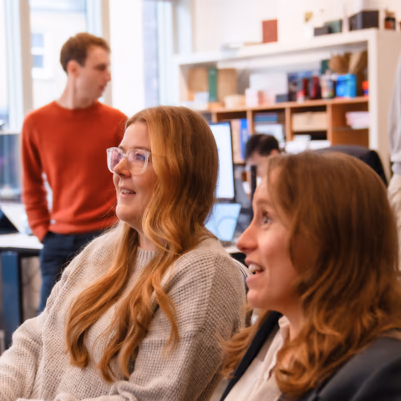 Modern office space with team collaborating around a desk, illustrating Sitruna’s partnership-driven approach to eCommerce success.