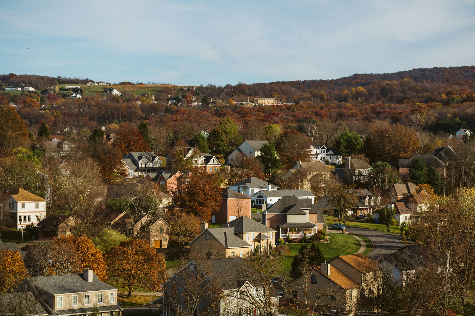 Autumn aerial view of a suburban neighborhood among colorful trees