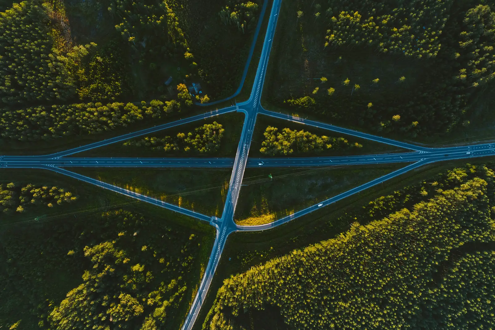 Aerial view of two roads crossing through a forest