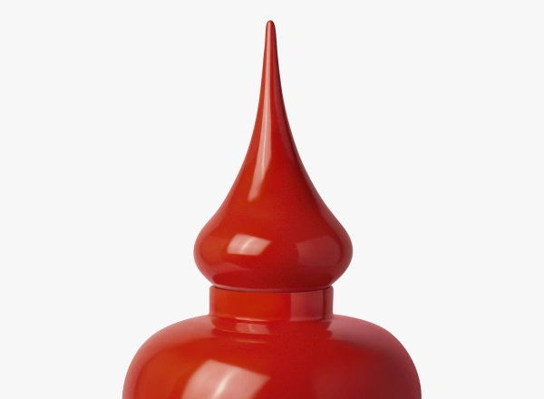 Close-up of a glossy red ceramic container with a tall, pointed lid.