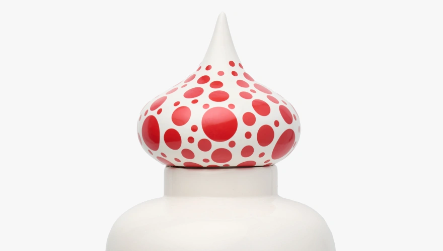 White ceramic sculpture with a bulbous top covered in various sized red dots.