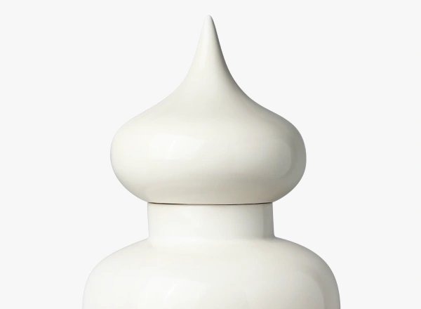 Close-up of a smooth, white decorative ceramic finial with a rounded base and pointed top.