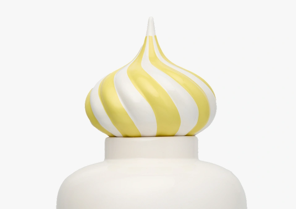 Close-up of a white container with a yellow and white striped swirled lid.