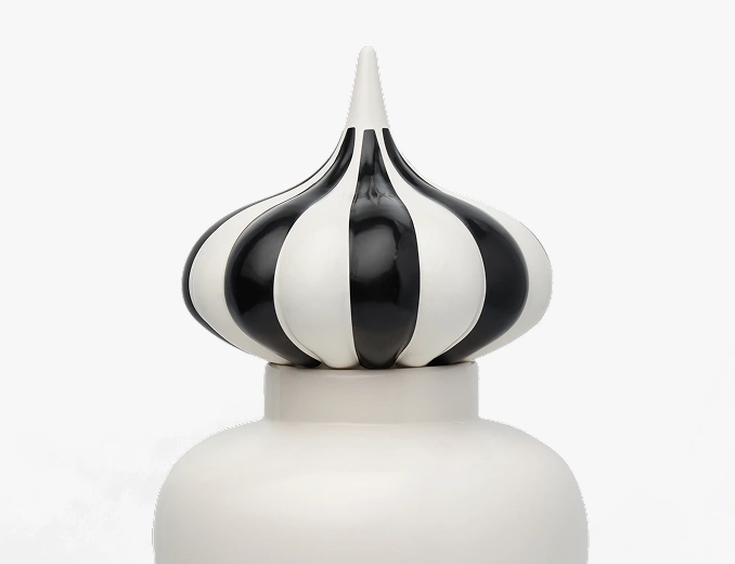 Top part of a decorative bottle with a black and white striped bulb-shaped stopper.