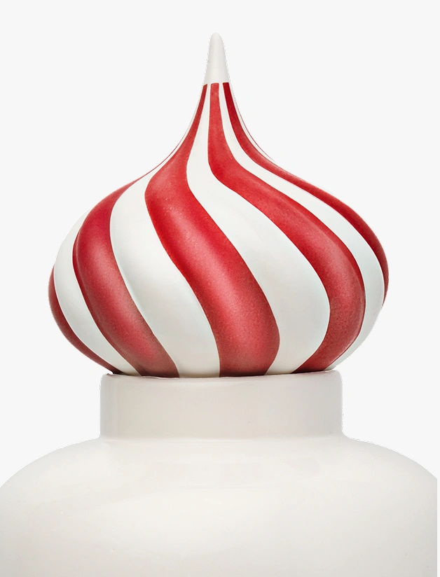 Close-up of a decorative finial with red and white twisted stripes on a white base.