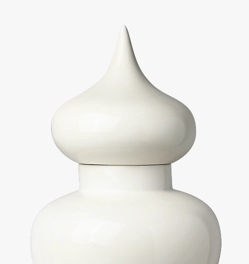 Close-up of white ceramic vase with a pointed, bulbous lid.