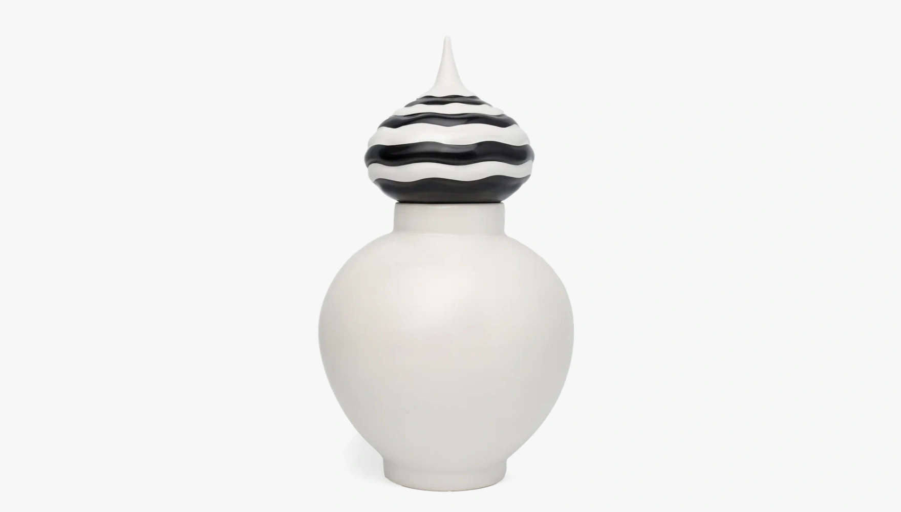 White ceramic jar with a round body and a black and white striped, wavy patterned pointed lid.