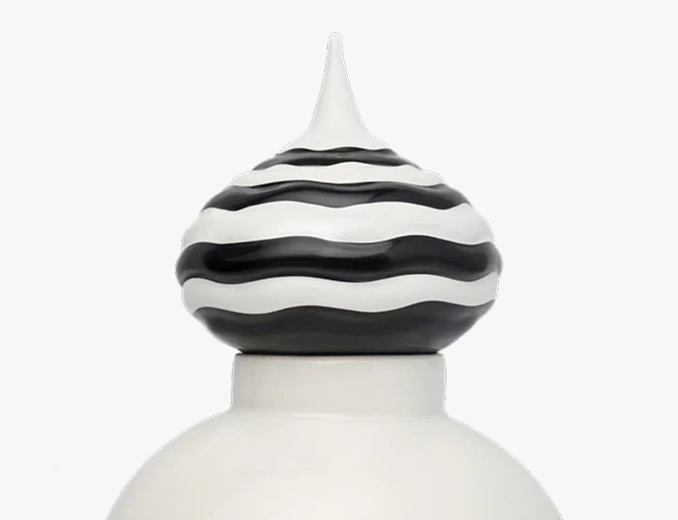 Decorative finial with black and white wavy stripes on top of a white rounded base.