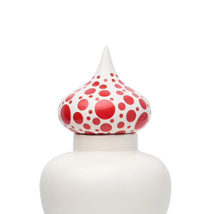 White decorative jar topped with a bulbous lid featuring red polka dots of varying sizes.