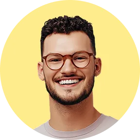 Portrait d'un homme souriant portant des lunettes et un t-shirt, sur fond jaune.